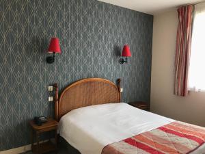 a bedroom with a bed and two lamps on the wall at Logis La Villa des Houx in Aumale