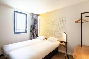 Säng eller sängar i ett rum på B&B HOTEL Cluses Sud
