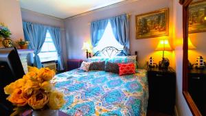 a bedroom with a large bed with blue curtains at Home Inn The Heart of the Finger Lakes in Geneseo