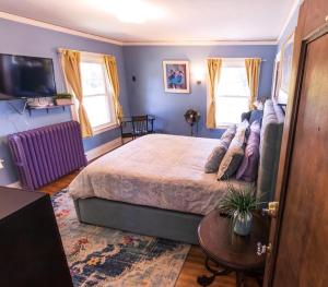 um quarto com uma cama grande e uma televisão em Home Inn The Heart of the Finger Lakes em Geneseo