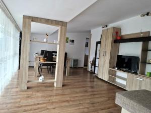 a living room with wooden floors and a dining room at Casa Elvina in Dubova