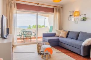 ein Wohnzimmer mit Couch und Blick aufs Meer in der Unterkunft #103 Foxy V by Home Holidays in Páteo