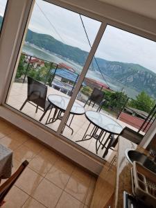 a balcony with tables and chairs and a large window at Casa Elvina in Dubova