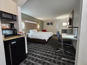 a large hotel room with a bed and a kitchen at Quality Inn & Suites Irving DFW Airport South in Irving