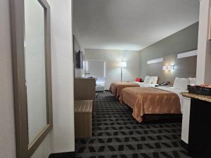 a hotel room with two beds and a mirror at Quality Inn & Suites Irving DFW Airport South in Irving