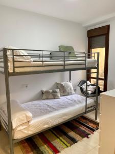 - une chambre avec deux lits superposés et un lit dans l'établissement Apartamento Pàmpol, à Lliber
