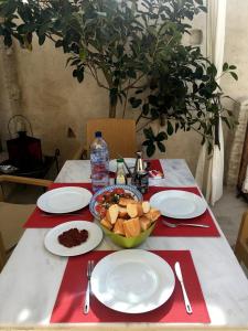 a table with plates of food and a bowl of bread at Riad Dar El Caid - Palais XIII Siecle in Tozeur