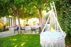 a swing in a yard with a table and chairs at ARMİ BUTİK OTEL in Cesme