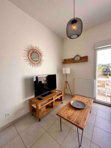 ein Wohnzimmer mit einem Holztisch und einem TV in der Unterkunft Lyon 9 • T2 Porcher • HostisY in Lyon