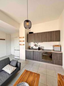 a living room with a couch and a kitchen at Lyon 9 • T2 Porcher • HostisY in Lyon
