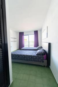 um quarto com uma cama com cortinas roxas em Coconut Apartments - Adults Only em Magaluf