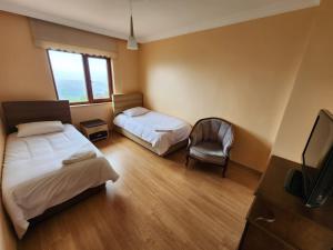 a room with two beds and a tv and a chair at Heaven Twın Villa in Zafanos