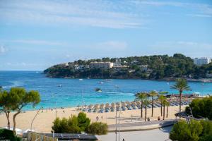 a beach with a bunch of umbrellas and the ocean at Coconut Apartments - Adults Only in Magaluf