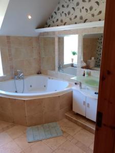 a large bathroom with a tub and two sinks at Tullynacrunat Lodge in Castleblayney