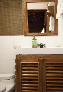 a bathroom with a sink and a mirror and a toilet at Tree House Lodge in Machu Picchu