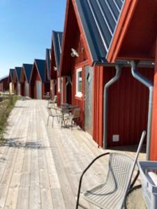 a row of chairs sitting on a boardwalk next to a building at Boat house with direct connection to the sea in Umeå