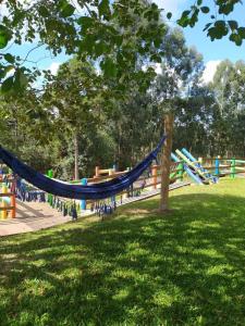 a playground with a blue hammock in a park at Recanto Paraíso Aventuras in Rio Negrinho