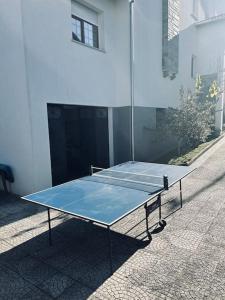 a tennis racket on a tennis court in front of a building at Duplex em casa inteiro. 4 quartos. Bem localizada. in Bragança