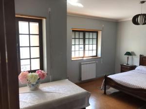 a bedroom with a vase of flowers on a table at Duplex em casa inteiro. 4 quartos. Bem localizada. in Bragança