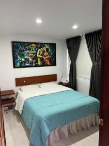 Schlafzimmer mit einem Bett mit Wandgemälde in der Unterkunft Hotel Tempus in Pasto