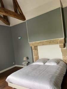 - une chambre avec un lit blanc et un plafond en bois dans l'établissement Le Logis Cholet 49300 lieu exceptionnel en famille ou amis, à Mazières-en-Mauges