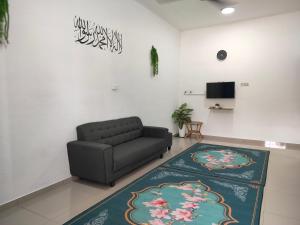 - un salon avec un canapé et un tapis dans l'établissement Dina Homestay B, à Pasir Puteh