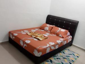 - un lit avec des draps et des oreillers orange et blancs dans l'établissement Dina Homestay B, à Pasir Puteh