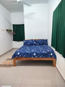 Bett in einem Zimmer mit grünen Vorhängen in der Unterkunft Dina Homestay B in Pasir Puteh