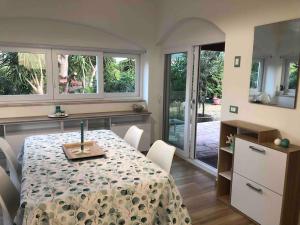 a dining room with a table and chairs and windows at Villetta Palmina in Porto Azzurro