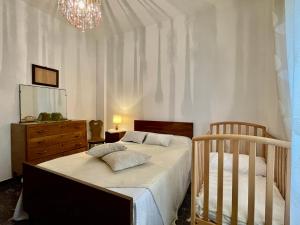 a bedroom with a bed and a dresser and a crib at [Menosio] La casa di Ermelinda - Relax in Arnasco