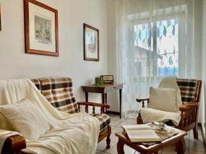 a living room with chairs and a table and a window at [Menosio] La casa di Ermelinda - Relax in Arnasco