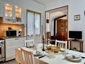 une cuisine avec une table et des chaises dans l'établissement [Menosio] La casa di Ermelinda - Relax, à Arnasco