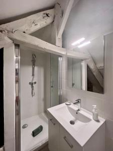 y baño blanco con lavabo y ducha. en Maison du Vieux Marché - Grande et Typique - Meyssac, en Meyssac