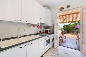 a white kitchen with a sink and a dishwasher at Casa Ghibli in Loano