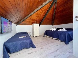 1 dormitorio con 2 camas y techo de madera en Casa Max & Lory by Holiday World en Cogoleto
