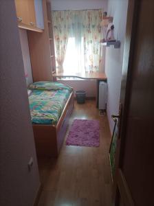 a small bedroom with a bed and a desk and a window at Casa Víctor in Ciudad-Rodrigo