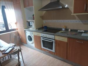 a kitchen with a stove and a washing machine at Casa Víctor in Ciudad-Rodrigo