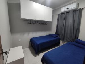 a room with two beds and a white cabinet at Condomínio Dunas Residence - Casa 7 e Casa 10 - Santo Amaro - MA in Santo Amaro