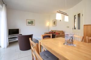 a dining room and living room with a wooden table at Sanddornweg Wohnung 13 b in Boltenhagen