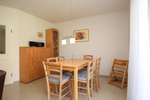 a dining room with a wooden table and chairs at Sanddornweg Wohnung 13 b in Boltenhagen