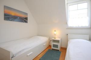a bedroom with two beds and a window at Sanddornweg Wohnung 13 b in Boltenhagen