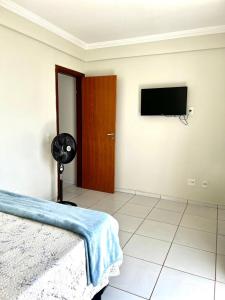 1 dormitorio con 1 cama y TV de pantalla plana en Apartamentos em Vicente Pires, en Brasilia