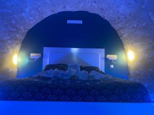 una habitación azul con una cama con dos personas en ella en Trog'Love: Balnéo détente dans une troglodyte, en Tours