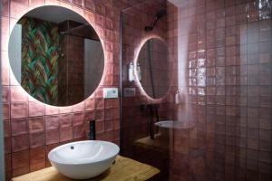 łazienka z umywalką i lustrem w obiekcie Apartamentos Milord w mieście El Puerto de Santa María