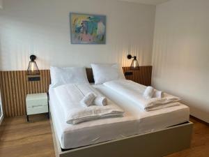 een slaapkamer met een groot bed met witte lakens en kussens bij Apartment MAJA by Krone Travel Agency in Zell am See