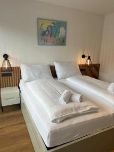 twee witte bedden in een kamer met twee lampen bij Apartment MAJA by Krone Travel Agency in Zell am See