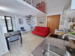 een keuken en een woonkamer met een rode bank bij Maridea - La Darsena in Ponza