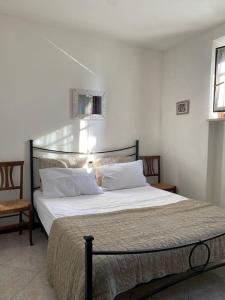 - un lit avec des draps et des oreillers blancs dans une chambre dans l'établissement 3 Bedroom Villa, Lake Garda, à Lazise