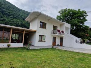 a white house with a balcony and a yard at Renate House in Băile Herculane