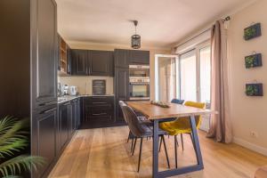 リル・ルッスにあるFornole - Appt vue mer pour 6 voyageursの部屋に木製のテーブルと椅子が置かれたキッチン
